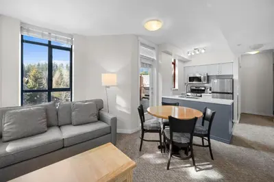 a living room with a couch and a table at Alpenglow Lodge Two Bedroom Apartment with Private Hot Tub by MVA in Whistler