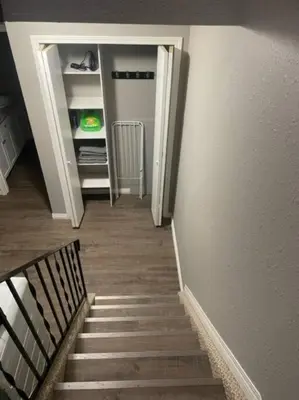 a hallway with a stairway leading to a closet at Lovely 2 Bedroom apartment in Camrose