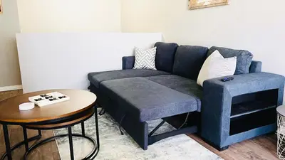 a living room with a blue couch and a table at Lovely 2 Bedroom apartment in Camrose