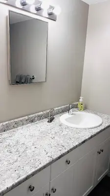 a bathroom counter with a sink and a mirror at Lovely 2 Bedroom apartment in Camrose