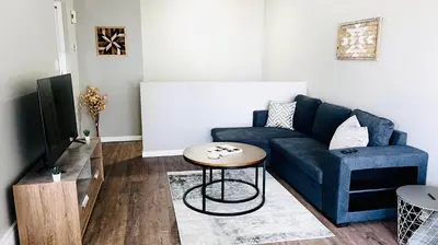 a living room with a blue couch and a table at Lovely 2 Bedroom apartment in Camrose