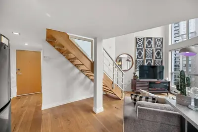 a living room with a staircase and a living room with a couch at Beautiful Downtown Loft with full kitchen in Vancouver