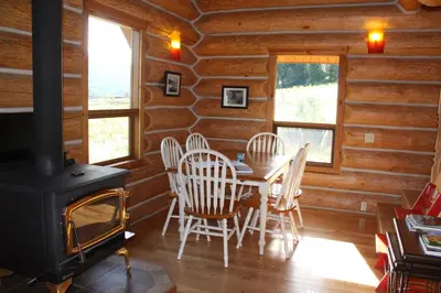 a dining room with a stove and a table and chairs at Bear Valley Highlands in Lumby