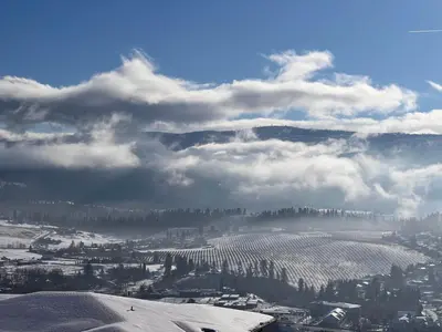 a view of a city with snow on the ground at Kelowna new lake view 2bedrooms close BIG WHITE in Kelowna