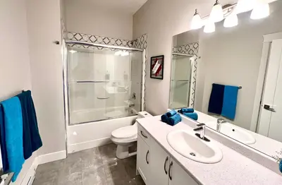 a bathroom with a sink and a toilet and a shower at Kelowna new lake view 2bedrooms close BIG WHITE in Kelowna