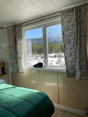 a bedroom with a window with a mountain view at Jade City Dog House in Jade City