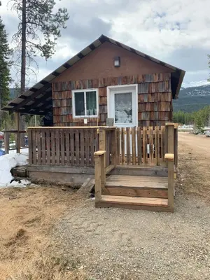 a log cabin with a porch and a fence at Jade City Dog House in Jade City
