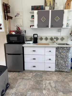 a kitchen with white cabinets and a microwave at Jade City Dog House in Jade City