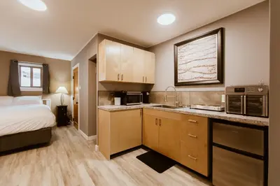 a bedroom with a bed and a kitchen with a sink at Lone Star Motel in Rossland