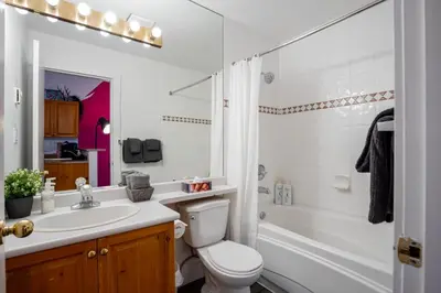 a bathroom with a toilet and a sink and a shower at The Après, Village Studio with Hot Tub and View in Whistler