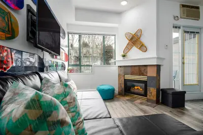 a living room with a couch and a fireplace at The Après, Village Studio with Hot Tub and View in Whistler