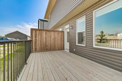 a wooden deck with a gate on a house at Brand New 3-Bedroom Home in a Quiet Neighborhood in Calgary
