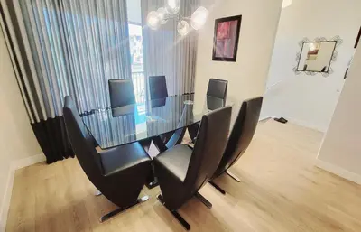 a dining room with a glass table and black chairs at Brand New 3-Bedroom Home in a Quiet Neighborhood in Calgary