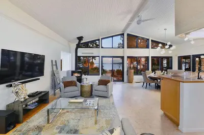 a large living room with a table and a tv at Beachside Living Cherry Point by EMR Vacation Rentals in Cobble Hill