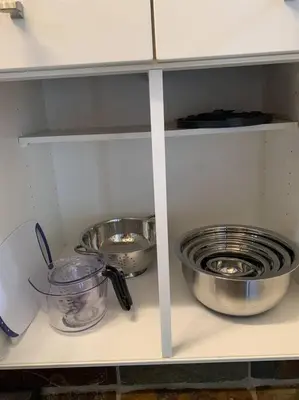 a shelf with bowls and other kitchen items on it at Chris Cozy Condo Commonwealth #205 Edmonton in Edmonton