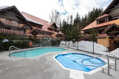 a swimming pool in front of a building at 3BR in Sunpath, King Bed, Village Location, Private Patios, Hot Tub and Pool in Whistler