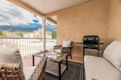 a screened in porch with a grill and chairs at Cozy Fairmont Hot Springs 1BR Condo in Fairmont Hot Springs