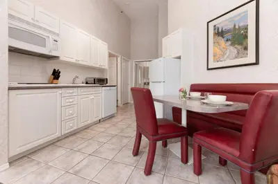 a kitchen with a table and red chairs in a room at Cozy Fairmont Hot Springs 1BR Condo in Fairmont Hot Springs