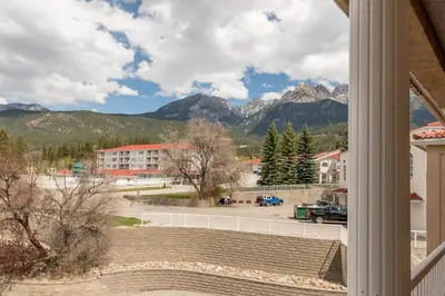 a view from a window of a parking lot with mountains at Cozy Fairmont Hot Springs 1BR Condo in Fairmont Hot Springs