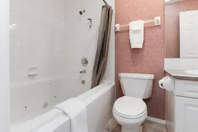 a bathroom with a toilet and a tub and a sink at Cozy Fairmont Hot Springs 1BR Condo in Fairmont Hot Springs