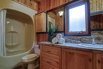 a bathroom with a toilet and a tub and a sink at Mountain Retreat, Panoramic Lake Views in Invermere