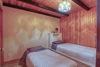 a bedroom with two beds and a chandelier at Mountain Retreat, Panoramic Lake Views in Invermere
