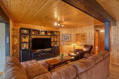 a living room with a couch and a television at Mountain Retreat, Panoramic Lake Views in Invermere