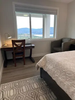 a bedroom with a desk and a bed and a chair at Shannon Heights B&B in West Kelowna