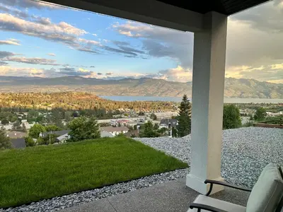 a patio with a view of a lake and mountains at Shannon Heights B&B in West Kelowna