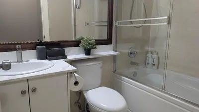 a bathroom with a toilet and a sink and a shower at Private Suite w King Bed, Ground Level, Naturally Bright in Vancouver