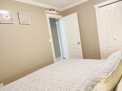 a small bedroom with a bed and a closet at Private Suite w King Bed, Ground Level, Naturally Bright in Vancouver