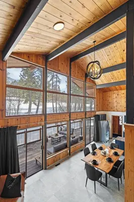 a dining room with a table and chairs and windows at The Matterhorn I HotTub I Ping Pong I Chalk Wall in Fairmont Hot Springs