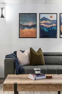 a living room with a couch and four paintings at The Matterhorn I HotTub I Ping Pong I Chalk Wall in Fairmont Hot Springs