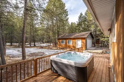 a hot tub on a deck next to a cabin at The Sleeping Moose I Fireplace I Pool Table I TV in Fairmont Hot Springs