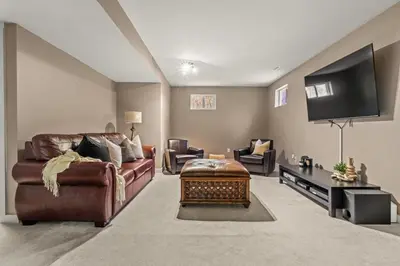 a living room with a couch and a flat screen tv at The Sleeping Moose I Fireplace I Pool Table I TV in Fairmont Hot Springs