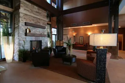 a lobby with a fireplace and couches and a lamp at Beautiful 2 bedroom town home in Sunrise Ridge in Parksville