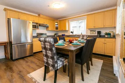 a kitchen with a wooden table and a stainless steel refrigerator at Cozy Renovated Oasis W Private Terrace & Parking in Victoria