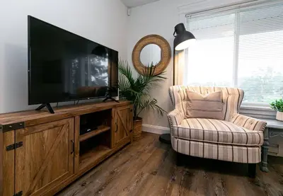 a living room with a flat screen tv and a chair at Cozy Renovated Oasis W Private Terrace & Parking in Victoria