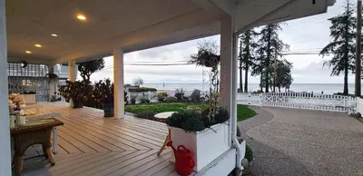 a porch of a house with a view of the ocean at The White House in Sechelt