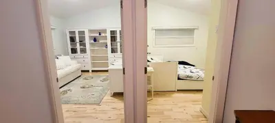 a room with a bedroom with a desk and a bed at The White House in Sechelt