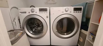 two washing machines sitting next to each other in a laundry room at The White House in Sechelt