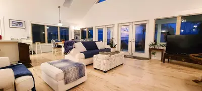 a living room with a couch and a tv at The White House in Sechelt