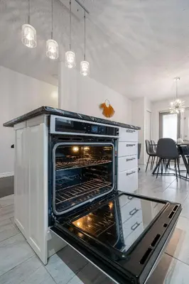 a kitchen with an oven in the middle of a room at Dino Roar I Sleeps 12 I New in Drumheller