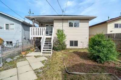 a house with a staircase in front of it at Dino Roar I Sleeps 12 I New in Drumheller