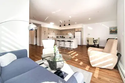 a living room with a blue couch and a kitchen at Spacious 2bedroom FREE parking king bed close to DT in Edmonton