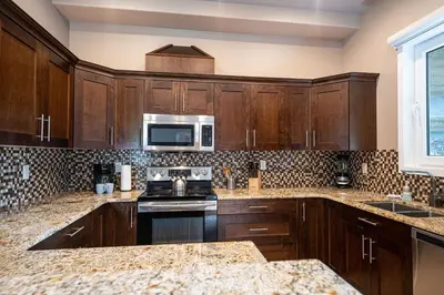 a kitchen with wooden cabinets and a microwave at Aspen Lodge by Revelstoke Vacations in Revelstoke