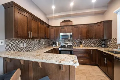 a kitchen with wooden cabinets and a granite counter top at Aspen Lodge by Revelstoke Vacations in Revelstoke