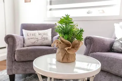 a teddy bear sitting on a coffee table in a living room at Stylish Close to D/T FREE parking King Bed 2bed in Edmonton