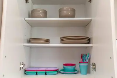 a closet with plates and bowls on shelves at Stylish Close to D/T FREE parking King Bed 2bed in Edmonton