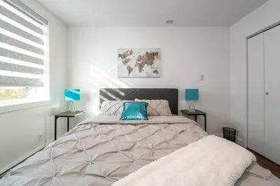 a bedroom with a large bed with a blue pillow at Stylish Close to D/T FREE parking King Bed 2bed in Edmonton